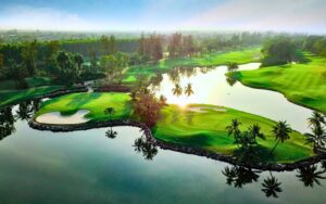 Vue aérienne spectaculaire de l’Alpine Golf & Sports Club en Thaïlande, mettant en valeur son parcours luxuriant entouré d’eau