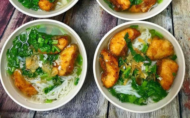 Quatre bols de bún cá rô đồng de Hà Nam, soupe de nouilles de riz garnie de morceaux de poisson frit doré, d’herbes fraîches et d’oignons frits dans un bouillon clair