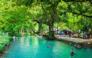 Le célèbre Blue Lagoon, avec ses eaux turquoise entourées de forêt luxuriante, où les visiteurs nagent et s’amusent avec une corde suspendue à un arbre