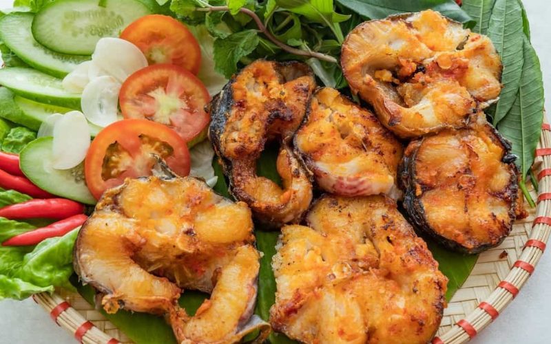 Plat de cá lăng grillé (poisson du fleuve Lo) servi avec légumes frais, tomates, concombres et piments rouges, spécialité culinaire de Phu Tho et Vinh Phuc