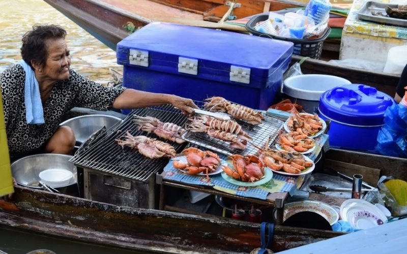 Fruits de mer frais préparés sur le bateau au marché flottant d'Amphawa