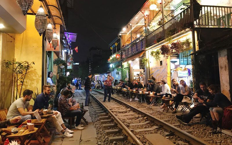Les touristes sirotent un café en attendant le passage du train