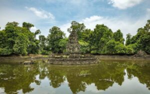 Temple de Neak Pean au Cambodge, situé sur une île circulaire au centre d’un bassin entouré de jungle luxuriante, avec un reflet paisible sur l’eau