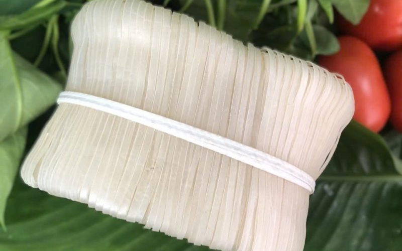 Gros plan sur un paquet de mỳ Chũ, nouilles plates de riz traditionnelles de Bac Giang, soigneusement attachées avec une ficelle blanche