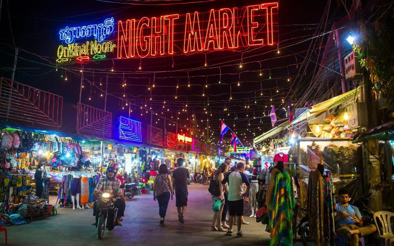 Le marché nocturne d'Angkor à Siem Reap, illuminé par des enseignes colorées et des guirlandes lumineuses
