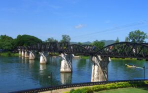 Vue du célèbre Pont sur la rivière Kwai à Kanchanaburi, Thaïlande, avec sa structure en acier emblématique, enjambant la rivière sous un ciel bleu