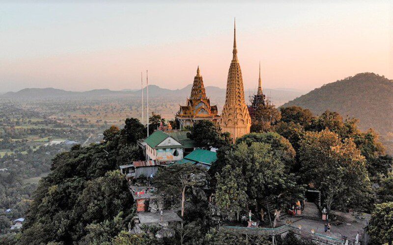 Temple bouddhiste perché au sommet d'une colline, entouré de végétation luxuriante