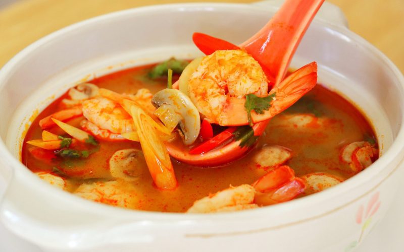 Un bol de soupe Tom Yum Goong thaïlandaise, riche en saveurs, avec des crevettes, des champignons, de la citronnelle, du piment et des herbes fraîches