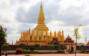 Vue du Pha That Luang à Vientiane, Laos, un grand stupa doré emblématique de l’architecture bouddhiste laotienne, sous un ciel nuageux